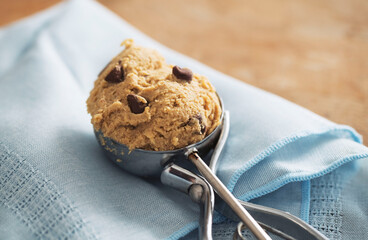 Scoop of edible cookie dough on blue napkin