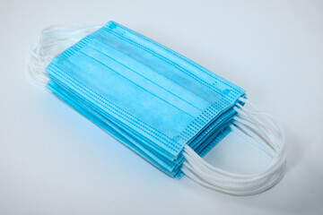 Isolated pile of stacked light blue ear loop mask