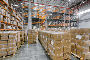 Large warehouse. Tall and long metal racks filled with various boxes, containers and drawers