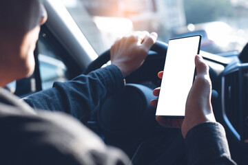 Mock up of man using blank screen mobile phone while driving a car
