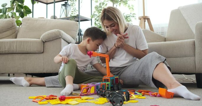 Mother and son celebrating after successfully assembling toy crane at home