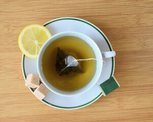 Cup of green tea with slices of lemon and sugar