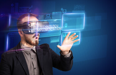 Businessman looking through Virtual Reality glasses with TECHNOLOGY IMPLEMENTATION inscription, new technology concept