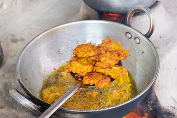 Kofta (Fried Crispy Pakoda) deep fried in oil in pan on traditional stove