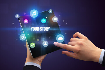 Businessman holding a foldable smartphone with YOUR STORY inscription, social media concept