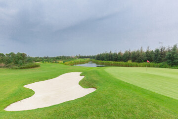 lake view golf course with bunkers clouds on a gloomy day
