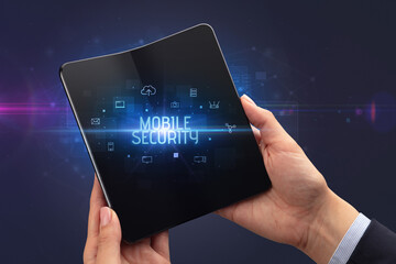 Businessman holding a foldable smartphone with MOBILE SECURITY inscription, cyber security concept