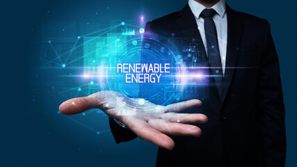Man hand holding RENEWABLE ENERGY inscription, technology concept