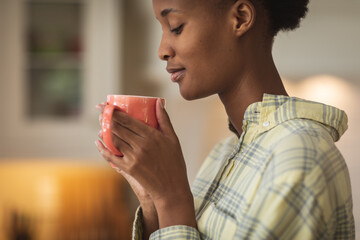 Woman holding coffee cup in the kitchen