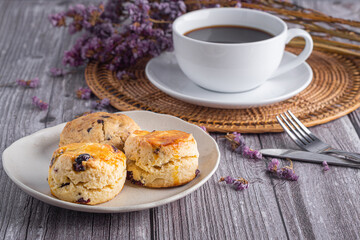 Traditional British scones and cookie with a tea cup and blurred background