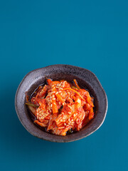 Traditional Korean dishes or Kimchi in a bowl on blue background