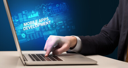 Businessman working on laptop with MOBILE APPS DEVELOPMENT inscription, cyber technology concept