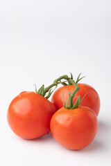 Fresh tomatoes on a green stem on white