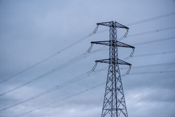 Large view of the powerlines on the field with cloudy background.