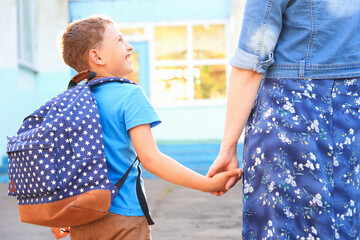 mom accompanies son to school. she encourages student to accompany him to school