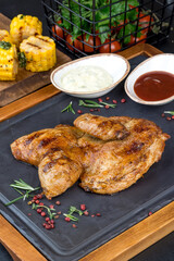 Grilled chicken served on a black slate board