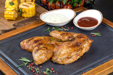 Grilled chicken served on a black slate board
