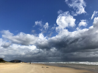 Australian beach with storm clouds and reflections in the sand, Mudjimba Beach, Queensland
