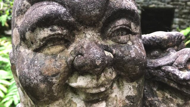 Details Of A Grungy Laughing Buddha Head Sculpture - extreme close up