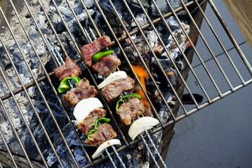 BBQ grilling meat with a bonfire outdoors