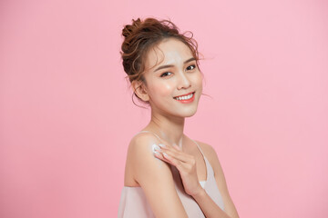Beautiful smiling woman with clean skin, natural make-up, and white teeth on pink background.