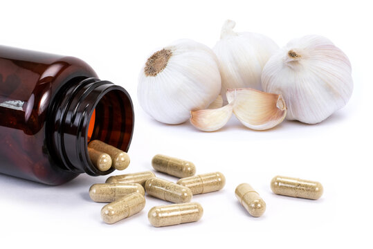 garlic with medicine capsule pills isolated on white.