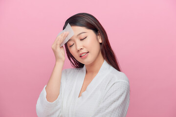 Young asian skin care woman smile and use oil blotting paper on her face