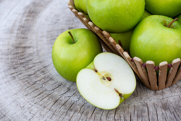 green apples with cut in half slice isolated on a wooden table