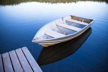 Naklejka na ściany i meble A close-up rowboat with reflection floating on Sequoia Lake, vacation