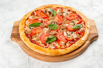 Round pizza with mushrooms and tomatoes on a wooden board
