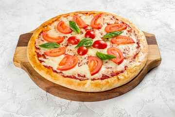 Round pizza with tomatoes and cheese on a wooden board