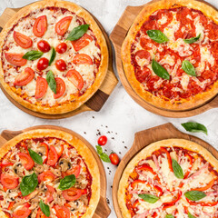 Four types of pizza shot from above on wooden boards