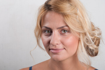 Closeup portrait of a young woman without makeup on a light