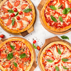 Four types of pizza shot from above on wooden boards