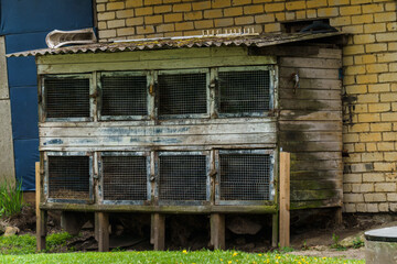 Rural life. Old cages for rabbits near a barn in the outback of Latvia, May 2020.