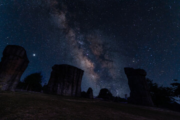 Milky way on the sky with hugh stone at Hin Klong Chang stone park, Chaiyaphum, Thailand