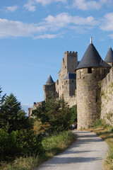 Fototapeta na wymiar Castillo de Carcasona, Francia, Provenza vista desde las muras exteriores, torres y entrada al final de un camino de adoquines