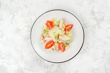 Caesar salad in a white, round plate shot from above