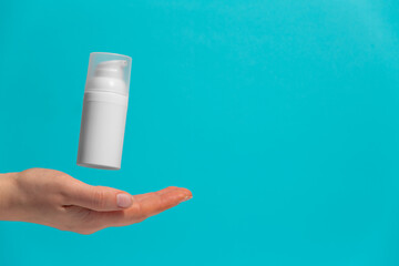Woman's hand with floating cosmetic product without brand, free space for text. Making advertisement.