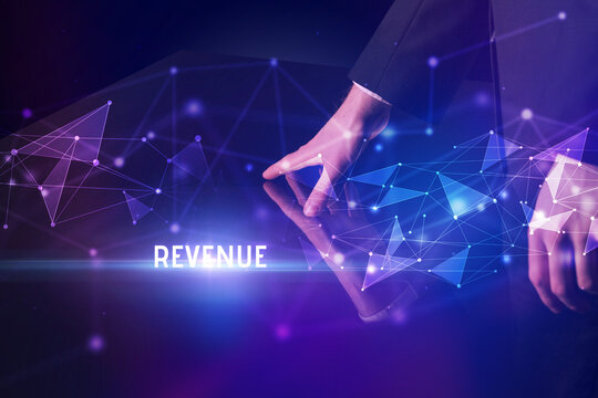 Businessman touching huge screen with REVENUE inscription, modern technology business concept
