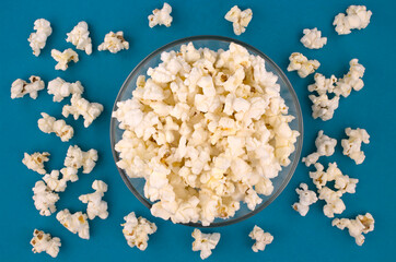 Popcorn in a bowl on blue background