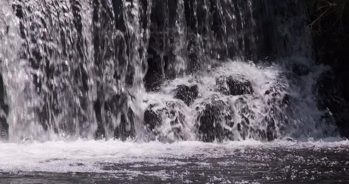 Clean, Clear Water Splashing On Rocks Below A Waterfall In River. Close Up.