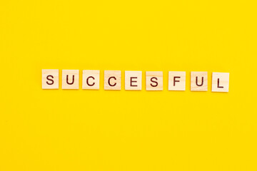 Wooden cubes inscription successful words on yellow background