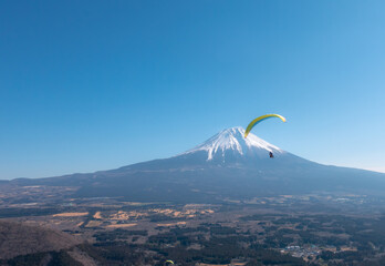 冠雪した富士山に向かって飛ぶパラグライダー　冬　2月