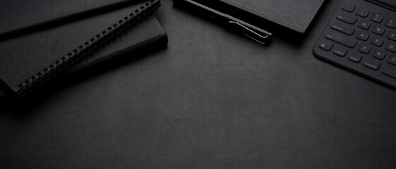 Luxury dark workspace with schedule books, pen, digital tablet with keyboard and copy space