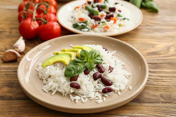 Plate with tasty rice, beans and avocado on table