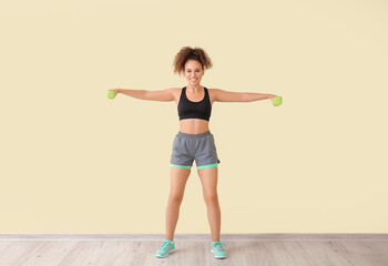 Fototapeta premium Sporty young woman training against light wall