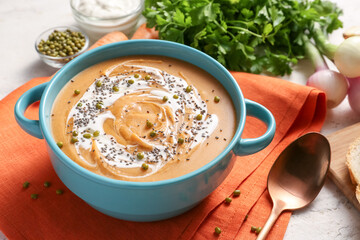 Pot of tasty lentils soup on table