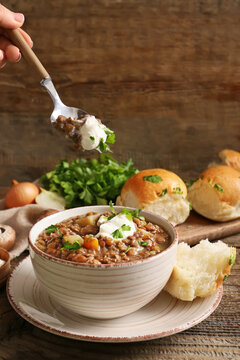 Woman Eating Tasty Lentils Soup From Bowl On Table