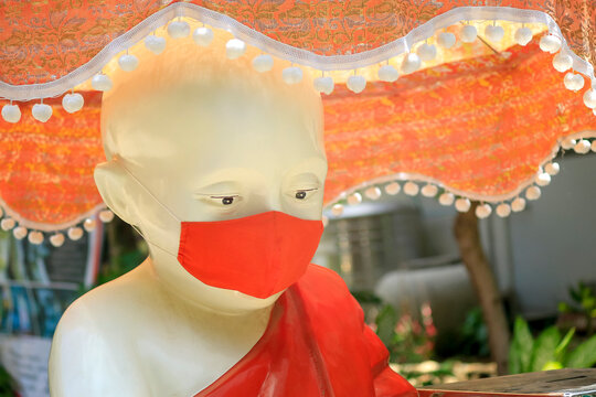 Buddha statue, wearing mask, conceptual, covic 19, corona virus, close-up of the Buddha statue.